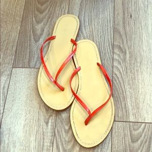 J. Crew flip flops with orange straps.